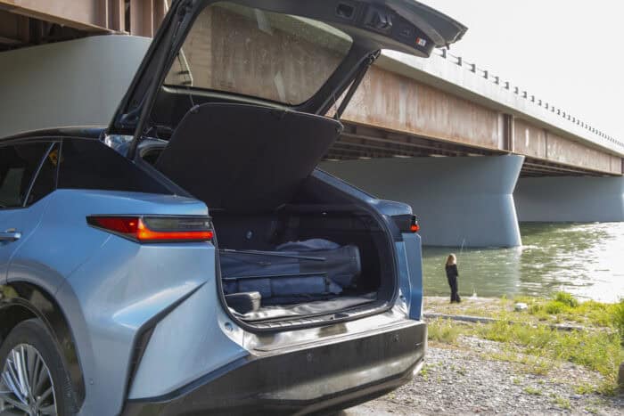 2026 Lexus RZ 450e trunk with golf clubs and person fly fishing in the back