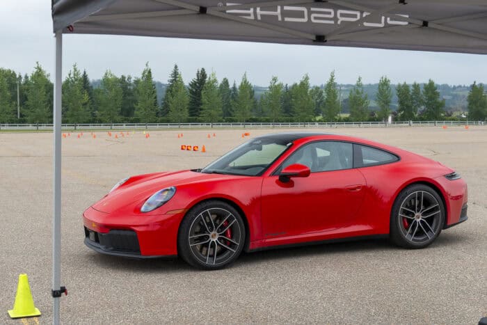 Red 2026 Porsche 911 Carrera GTS front view parked on small track