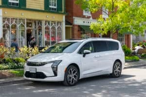 White 2027 Chrysler Pacifica Pinnacle front parked on tourist street